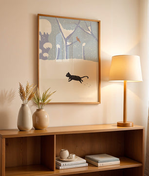 Paysage enneigé illustré avec un chat noir joueur et un oiseau dans un décor hivernal