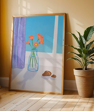 Jarrón con flores naranjas junto a una ventana con cortinas moradas