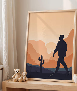 Silhouetted figure walking in desert landscape at sunset