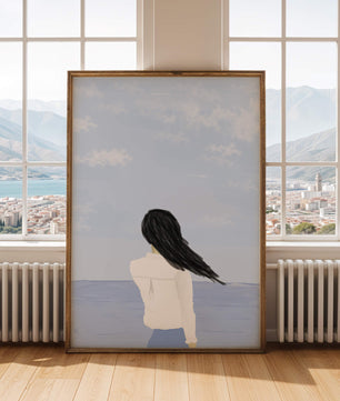 Woman gazing at the ocean with blue sky and clouds