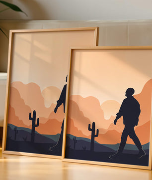 Silhouetted figure walking in desert landscape at sunset
