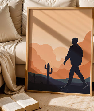Silhouetted figure walking in desert landscape at sunset