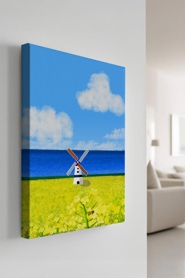 Scenic landscape with windmill in blooming field by the sea