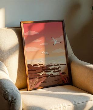 Seagulls flying over rocky coastline at sunset