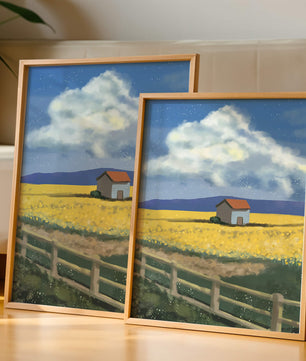 Idyllic rural scene with house and yellow field under blue sky