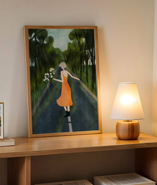 Femme en robe orange marchant sur une route avec des fleurs dans la forêt
