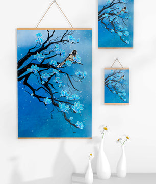 Bird on a branch with blue flowers against a snowy background
