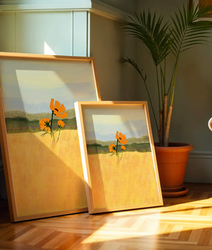 Orange Flowers in a Golden Field with Mountains and Blue Sky