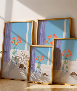 Jarrón con flores naranjas junto a una ventana con cortinas moradas