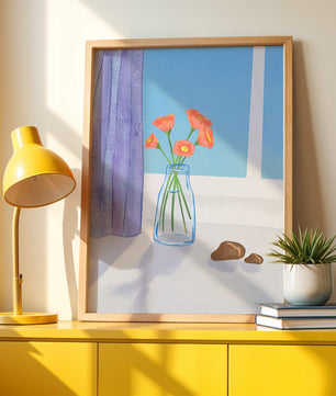 Jarrón con flores naranjas junto a una ventana con cortinas moradas