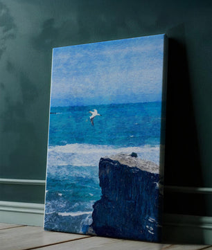 Paisaje marino con gaviota volando sobre acantilado rocoso y olas del océano
