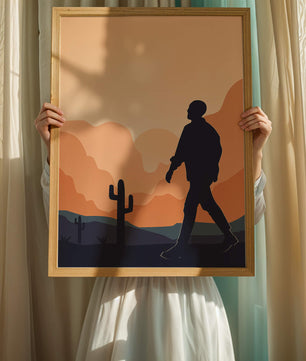 Silhouetted figure walking in desert landscape at sunset