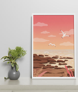 Seagulls flying over rocky coastline at sunset