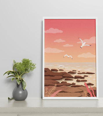 Seagulls flying over rocky coastline at sunset