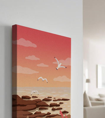 Seagulls flying over rocky coastline at sunset