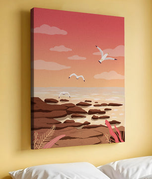 Seagulls flying over rocky coastline at sunset