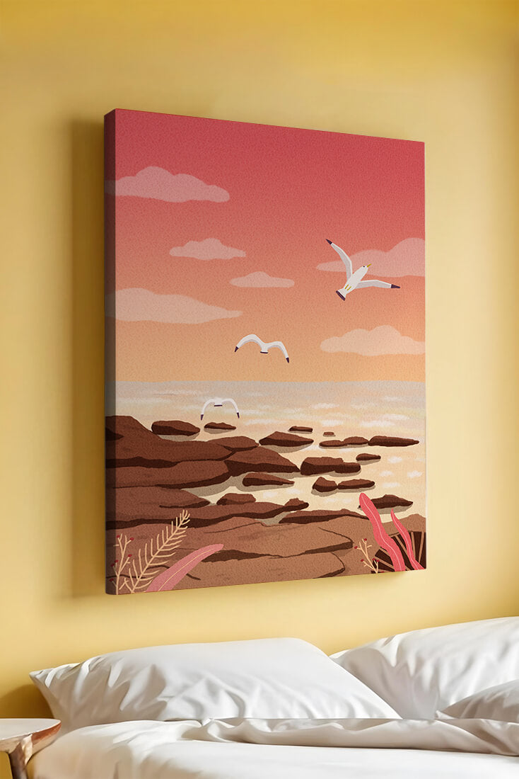 Seagulls flying over rocky coastline at sunset