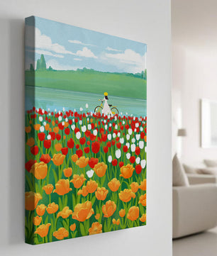 Woman with bicycle in vibrant tulip field by a lake