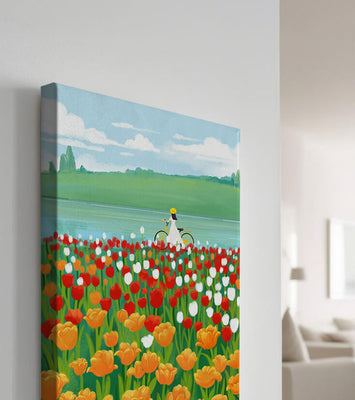 Woman with bicycle in vibrant tulip field by a lake