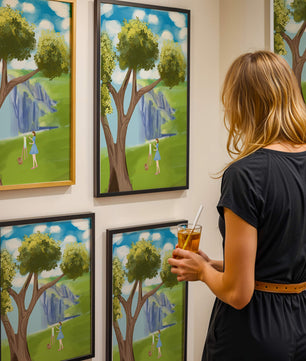 Young woman painting near a tree by a waterfall with a vibrant sky
