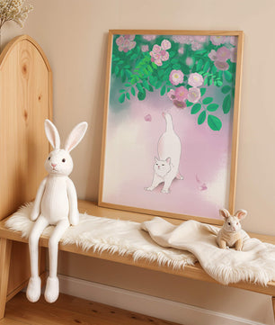 White cat stretching beneath blooming flowers in a pastel garden setting