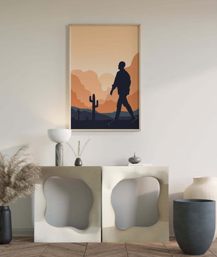Silhouetted figure walking in desert landscape at sunset