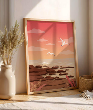 Seagulls flying over rocky coastline at sunset