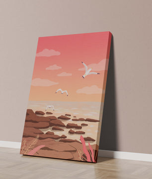 Seagulls flying over rocky coastline at sunset