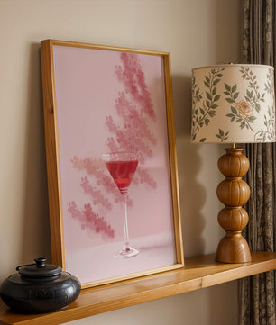 Elegante copa de cóctel roja sobre un fondo texturizado rosa