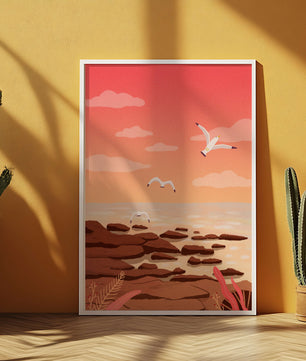 Seagulls flying over rocky coastline at sunset