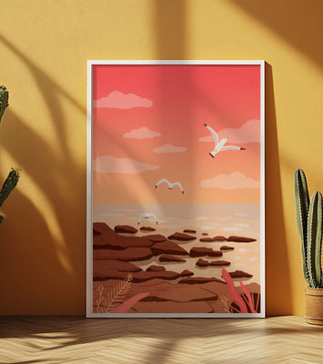 Seagulls flying over rocky coastline at sunset