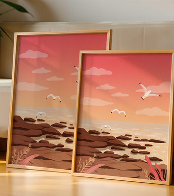 Seagulls flying over rocky coastline at sunset