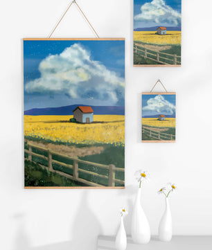 Idyllic rural scene with house and yellow field under blue sky