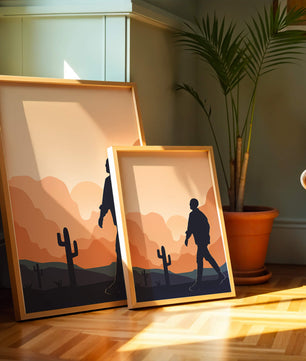 Silhouetted figure walking in desert landscape at sunset