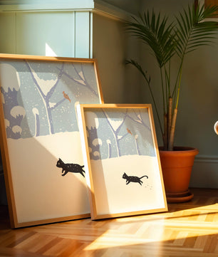 Paysage enneigé illustré avec un chat noir joueur et un oiseau dans un décor hivernal