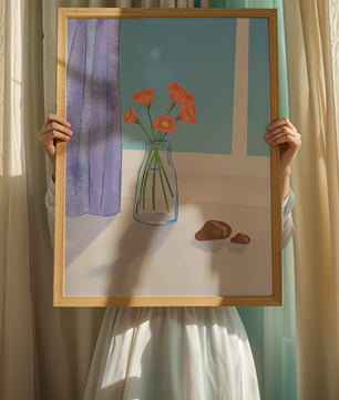 Jarrón con flores naranjas junto a una ventana con cortinas moradas