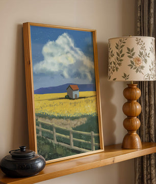 Idyllic rural scene with house and yellow field under blue sky