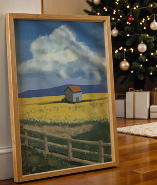 Idyllic rural scene with house and yellow field under blue sky