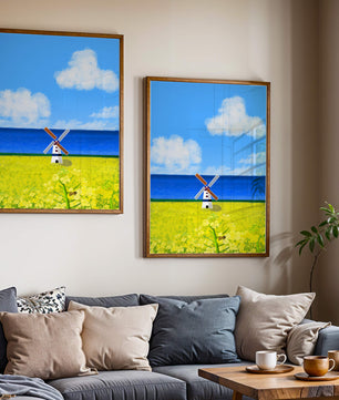 Paisaje pintoresco con molino de viento en un campo floreciente junto al mar