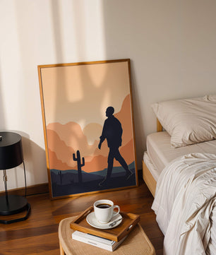 Silhouetted figure walking in desert landscape at sunset