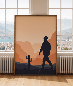 Silhouetted figure walking in desert landscape at sunset
