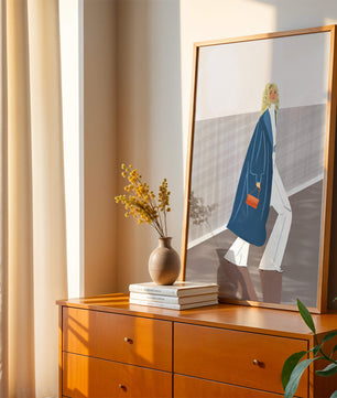 Fashionable Woman in Long Blue Coat Walking Along Corridor with Orange Handbag