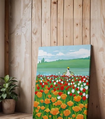 Woman with bicycle in vibrant tulip field by a lake