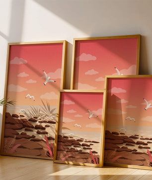 Seagulls flying over rocky coastline at sunset