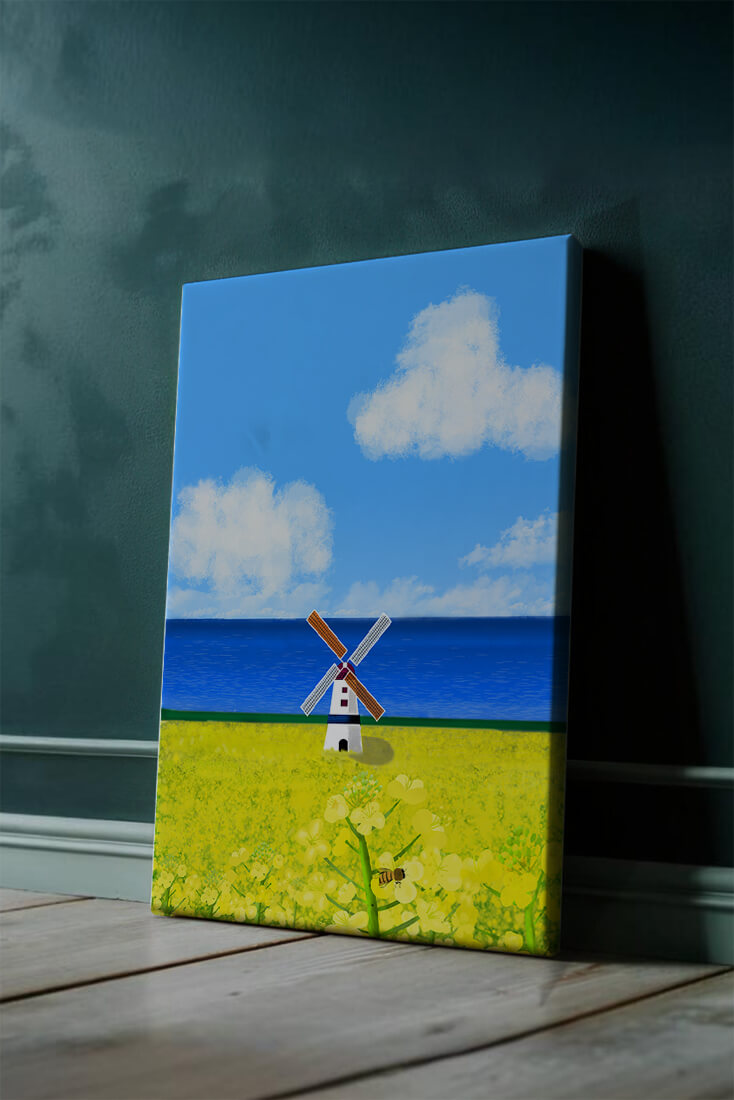 Scenic landscape with windmill in blooming field by the sea