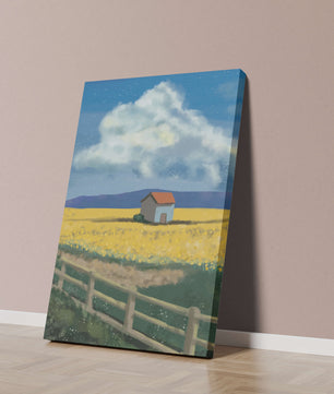 Idyllic rural scene with house and yellow field under blue sky