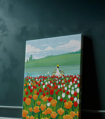 Woman with bicycle in vibrant tulip field by a lake