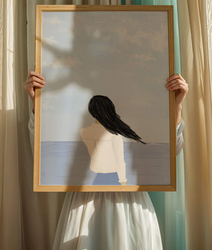 Woman gazing at the ocean with blue sky and clouds