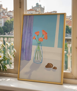 Jarrón con flores naranjas junto a una ventana con cortinas moradas