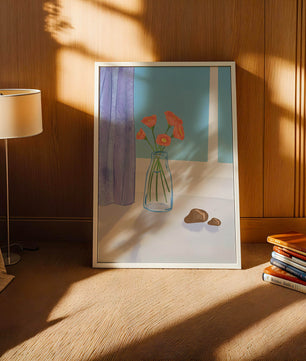 Jarrón con flores naranjas junto a una ventana con cortinas moradas